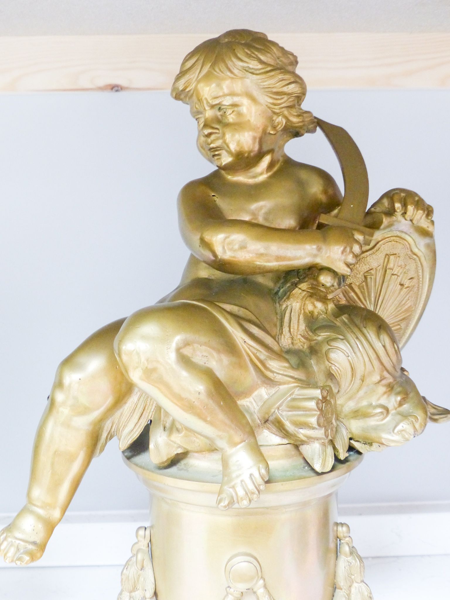 A pair of bronze figures of Cupid on circular pedestals, early 20th century, 42 cm high